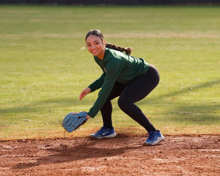 Softball player practicing a backhand fielding position at a dirt bros baseball camp hosted by coach trent mongero