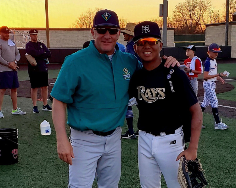 Trent and a camper posing for a photo after a baseball camp